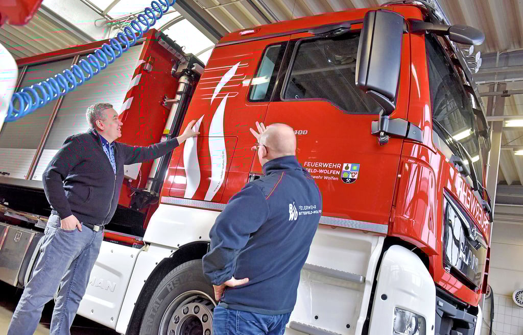 Die Feuerwehr der Stadt Bitterfeld-Wolfen hat ein neues Logo. Sebastian Gries (li.) und Patrick Quilitzsch stellen es schon mal kurz vor.