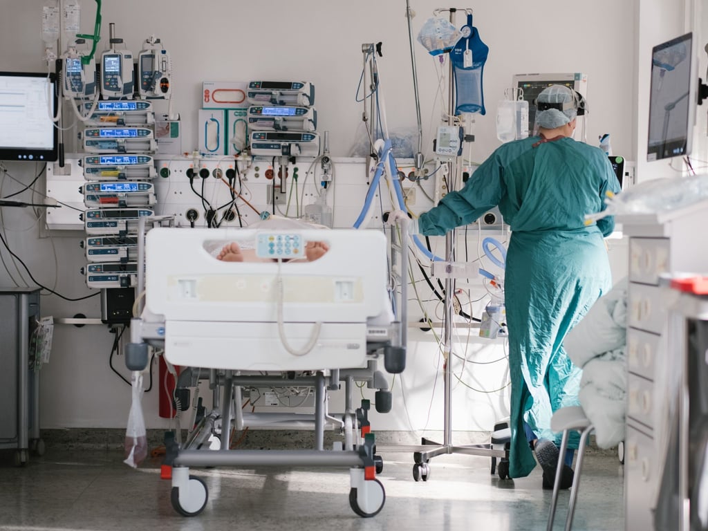 Eine Intensivpflegerin versorgt auf der Intensivstation einen an Covid-19 erkrankten Patienten.