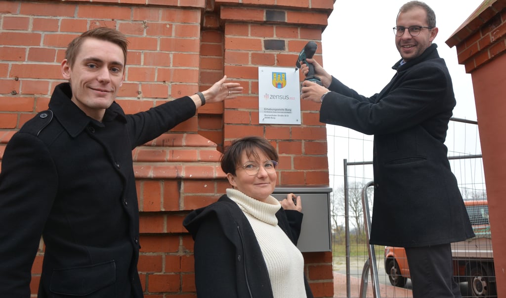 Im Verwaltungsgebäude des ehemaligen Schlachthofes an der Blumenthaler Straße schraubt Bürgermeister Philipp Stark die letzte Schraube des Zensus-Hinweisschildes in die Mauer. René Teßmann und Doreen Wichmann sind die ersten Mieter im denkmalgeschützten Haus.Haus.