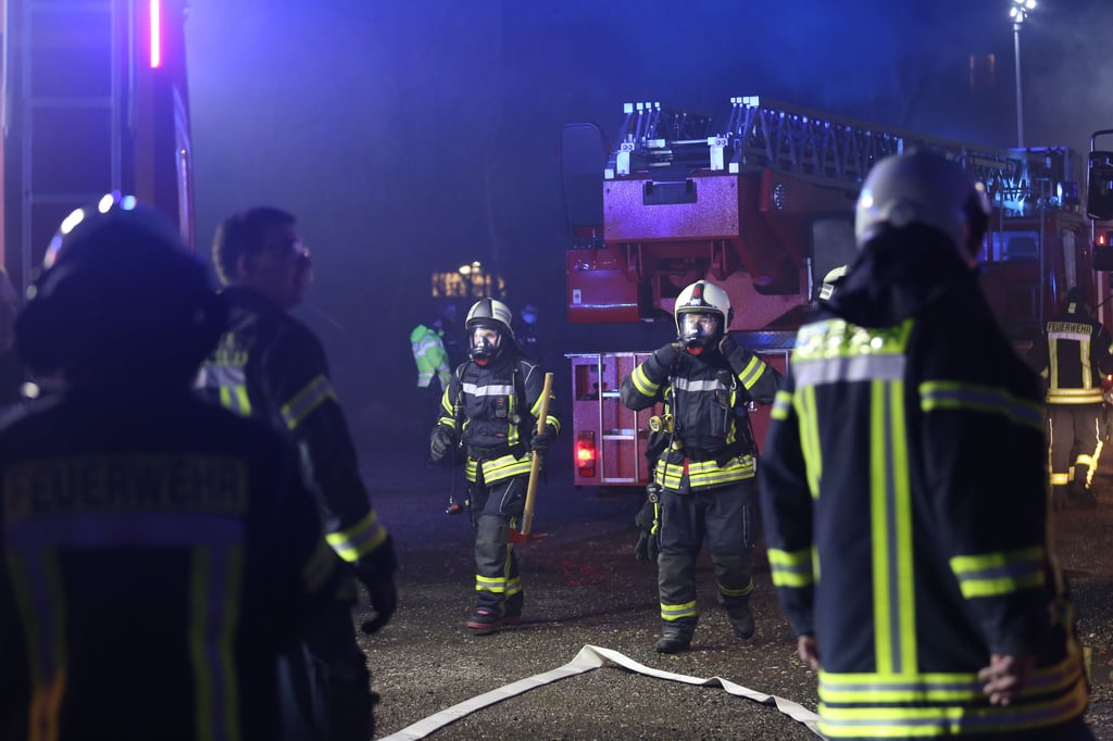 Atemschutzträger machen sich für den Einsatz beim Brand der Lagerhalle fertig.