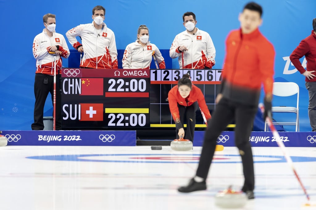 Jenny Perret (2.v.r.) und Martin Rios (r.) vom Schweizer Team und ihre Betreuer beobachten das chinesische Team vor dem Spiel.