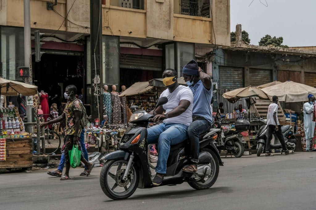 Mit Schutzmaske unterwegs auf dem Motorroller in Dakar. Von der Risikoliste gestrichen wird unter anderem Senegal.