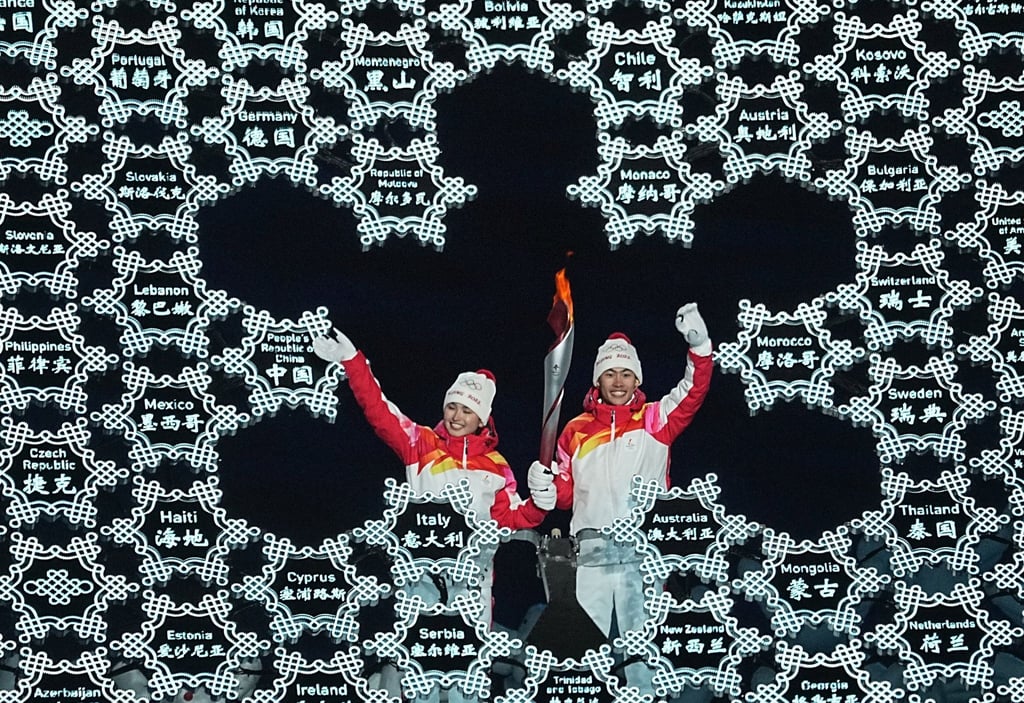 Chinas Zhao Jiawen (r) und Yilamujiang Dinigeer haben das olympische Feuer für die Winterspiele in Peking entzündet.