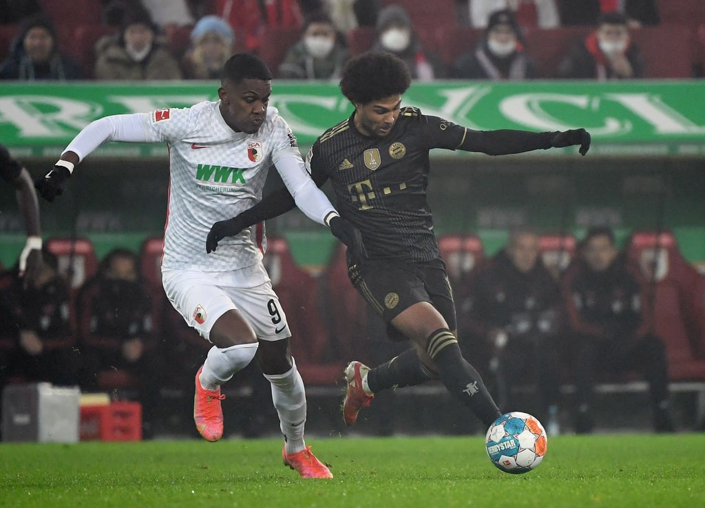 Augsburgs Stürmer Sergio Cordova (l) und Bayerns Mittelfeldspieler Serge Gnabry kämpfen um den Ball.