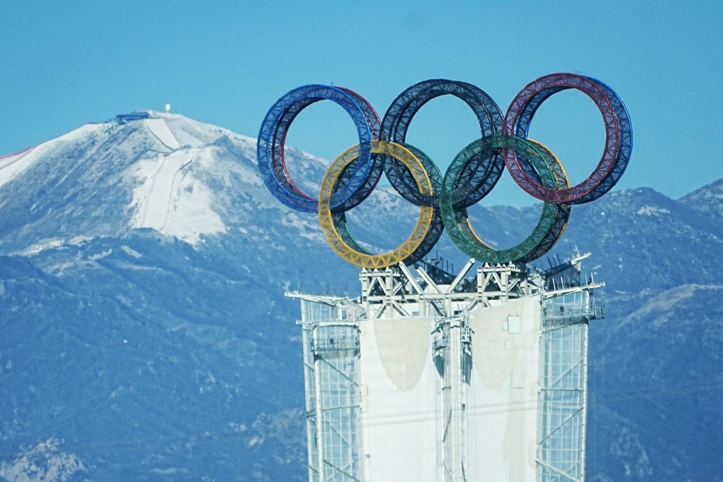 Blick auf einen Turm in der Yanqing-Region. Im Hintergrund ist der Start der alpinen Olympia-Abfahrt am Xiaohaituo Mountain im Nationalen Ski-Alpin-Zentrum zu sehen.
