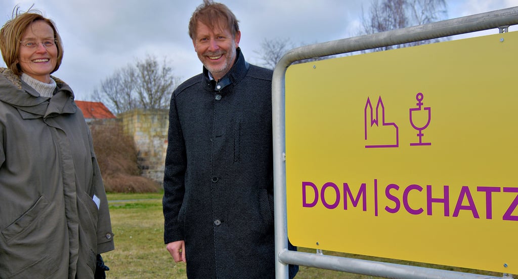 Uta-Christiane Bergemann, Museumsdirektorin des Halberstadt Domschatzes, und Peter Pinkernelle, Vorsitzender des Domvereins, an einem der vom Verein gespendeten neuen Hinweisschilder für Dom und Domschatz in Halberstadt.