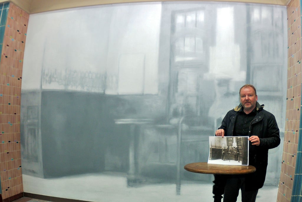 Thomas Harborth mit dem Foto, das die Vorlage für das Gemälde in der Halle des historischen Bahnhof in Oschersleben wurde.