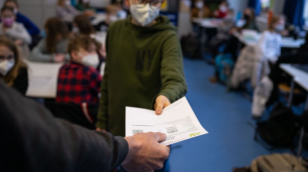 Eine Klassenlehrerin hält das Zeugnis eines Schülers. Am kommenden Freitag ist letzter Schultag vor den Winterferien