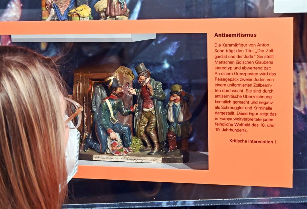 Die Keramikfigur „Die Zollrevision“ von Anton Sohn mit einem erklärender Text zum Antisemitismus im Badischen Landesmuseum in Karlsruhe.