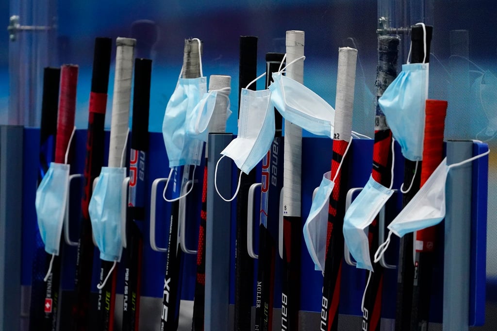 Masken hängen an Eishockeyschlägern der Schweizer.