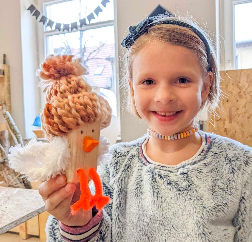 Rosalie (6) hat in der Holzwerkstatt einen Vogel gebaut und mit Mütze und Flügeln ausgestattet.