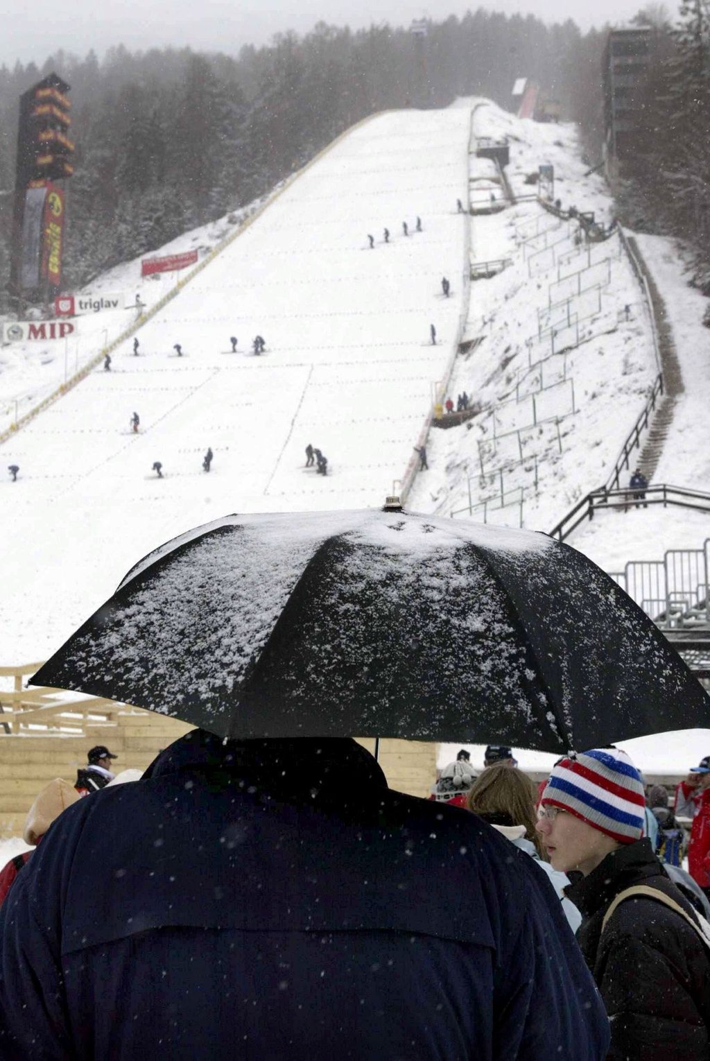 Zuschauer harren am Fuße der Sprungschanze in Planica aus.