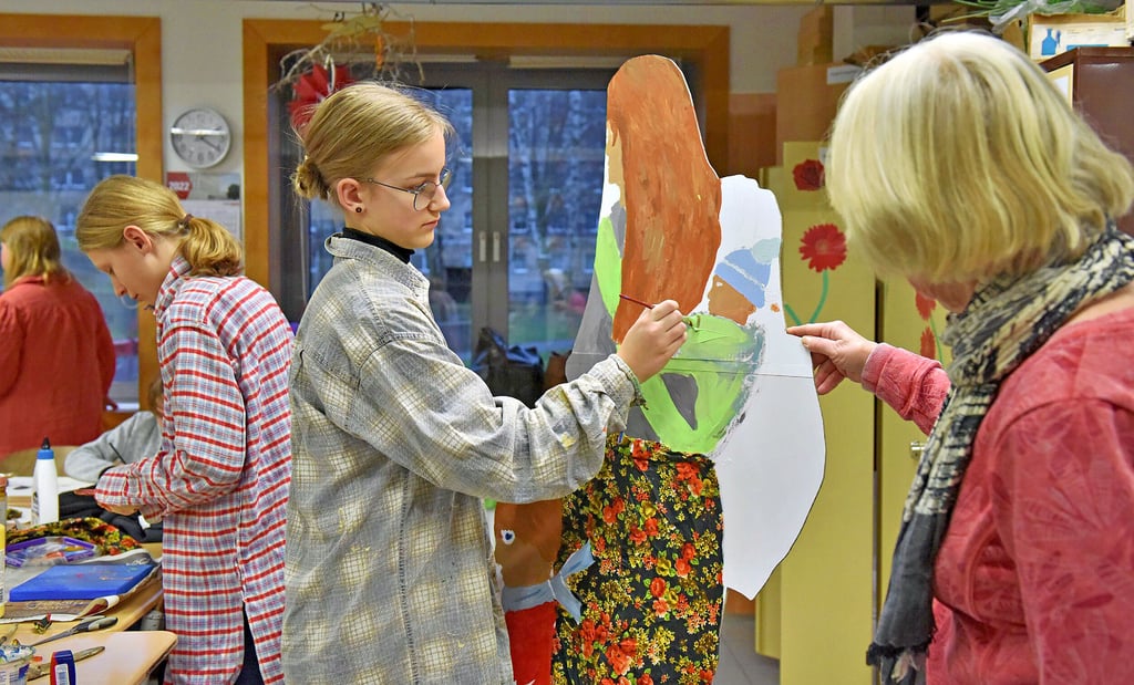 Lilly Nordhausen malt an der Ausstellungsfigur, die die Junge Gruppe Kunst für eine Ausstellung in Marl vorbereitet.