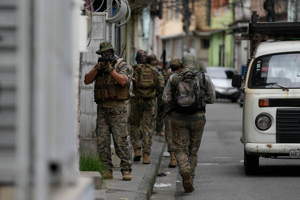 Ein Militärpolizist der Spezialeinheiten richtet seine Waffe während eines Einsatzes gegen mutmaßliche Drogenhändler in der Favela Vila Cruzeiro in Rio de Janeiro.