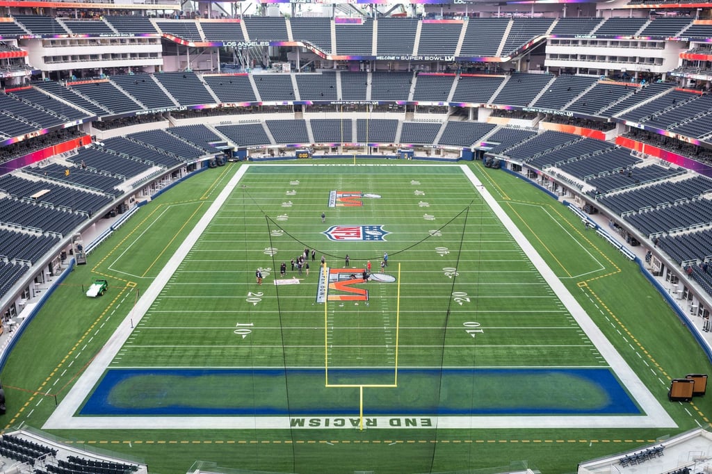 Arbeiter malen das Logo des Super Bowl LVI auf das Spielfeld im SoFi Stadion.