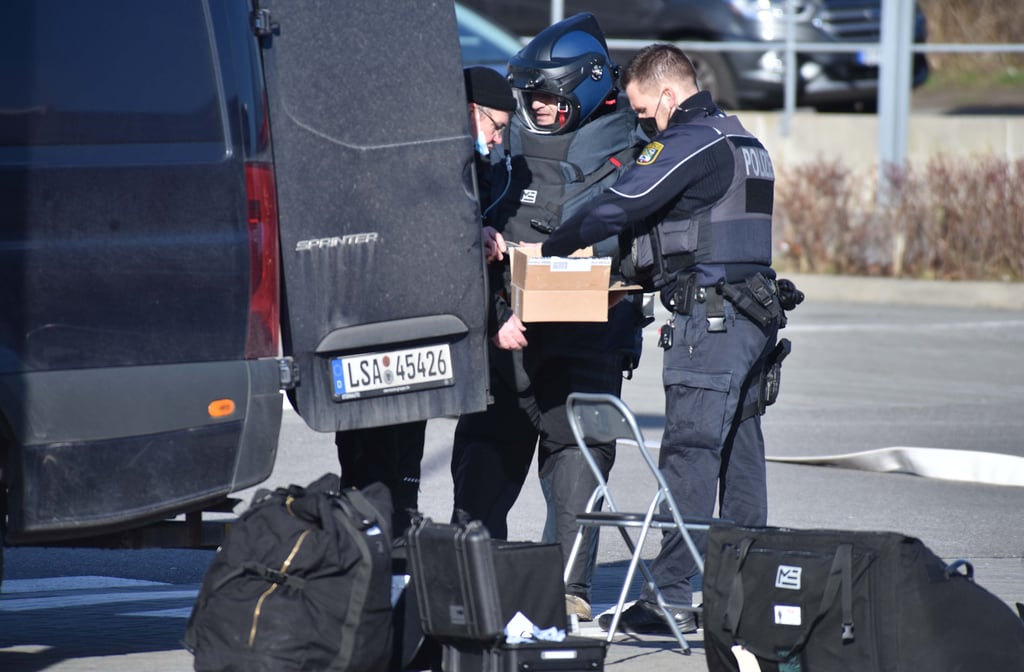 Polizeisten haben das verädchtige Paket nach draußen gebracht.