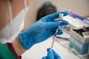 Eine Mitarbeiterin eines Impfteams zieht den Impfstoff von Biontech/Pfizer in eine Spritze auf.