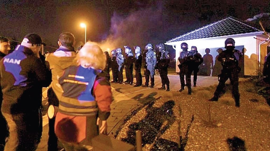 Mob zieht vor das Haus des Oberbürgermeisters von Halberstadt. Polizisten stellen sich in einer Linie davor.