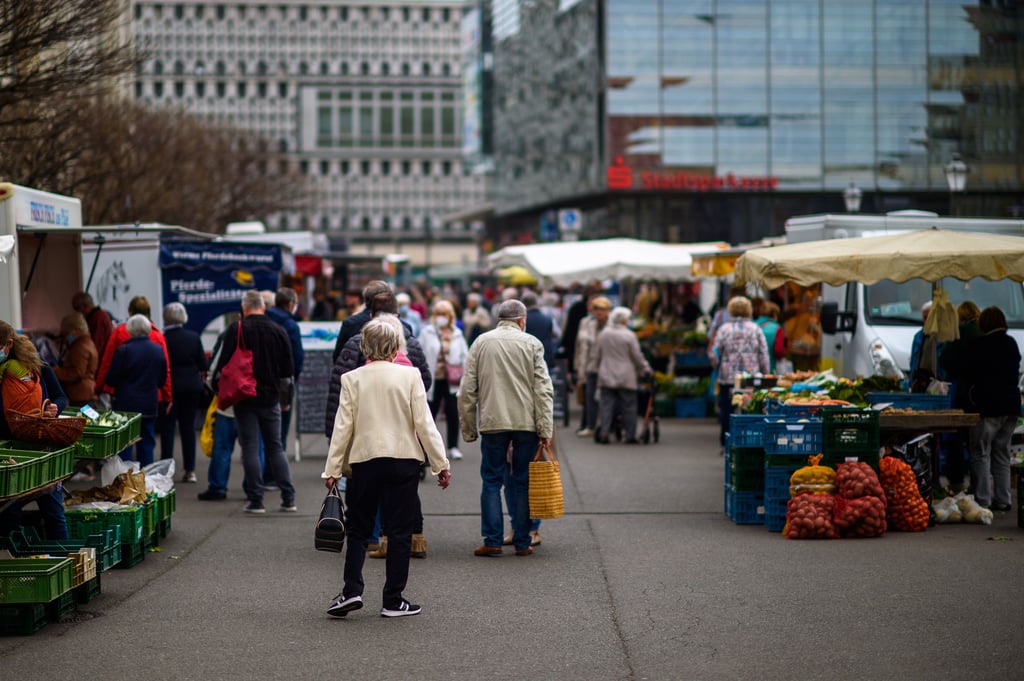Einkäufer gehen über den Wochenmarkt in Magdeburg.
