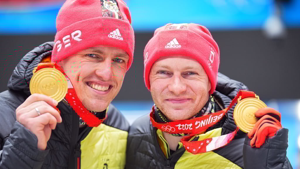 Francesco Friedrich (r.) und Thorsten Margis präsentieren stolz ihr Olympia-Gold in Peking.