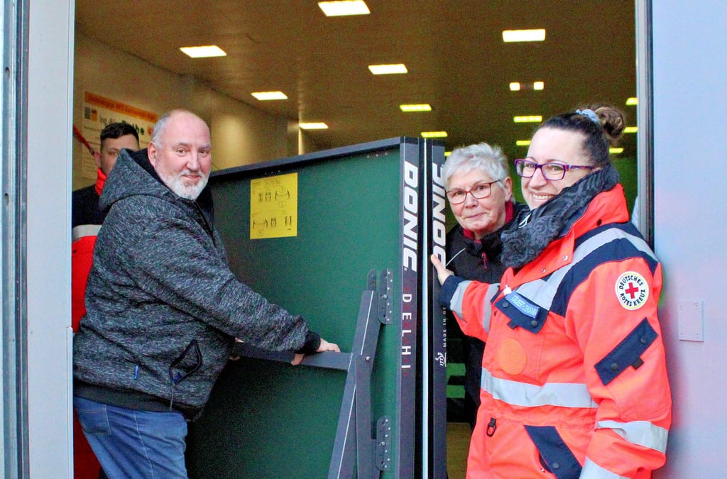 Henry Gräfe, Karin Neubauer und Kerstin Täubert (v.l.) holen eine der Tischtennisplatten aus der Turnhalle der SG Jeßnitz.