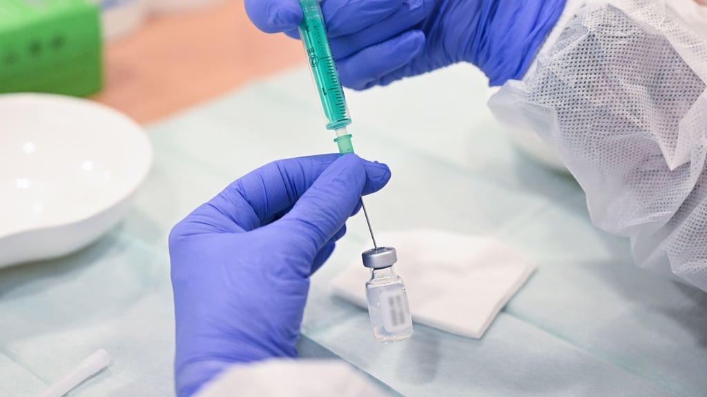 In einer Impfstation wird eine Spritze für eine Impfung gegen das Coronavirus vorbereitet.