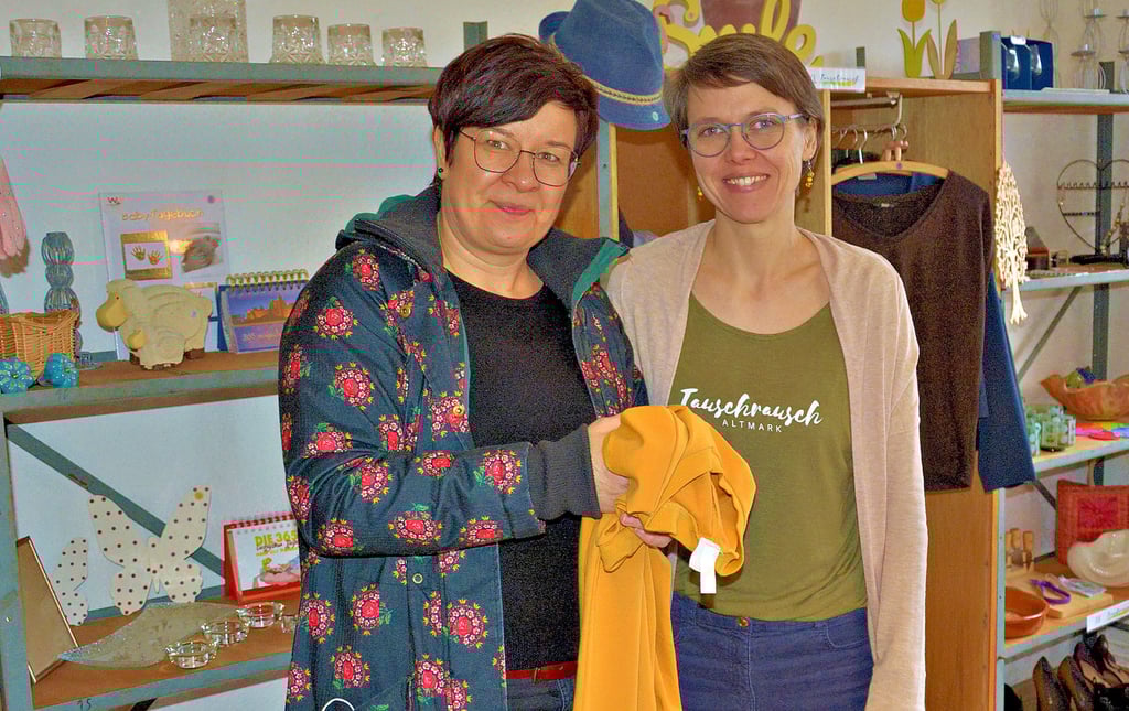 Kristin Henneick (links) stöbert bei Tauschrausch Altmark Initiatorin Christine Leneke durch den kleinen Ausstellungsraum, in dem einige Tausch-Artikel angeschaut werden können. Das gelbe Kleid hat ihr Herz erobert.