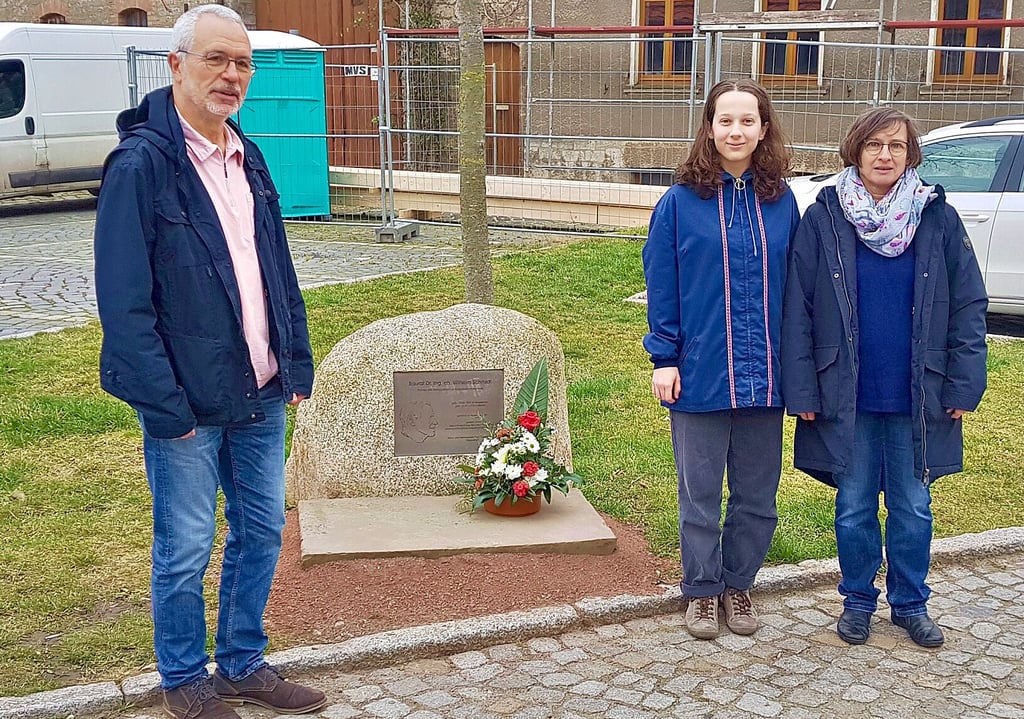 Am Gedenkstein im Kuhley in Wegeleben legten Karl-Heinz Becker sowie Katharina und Karin Bäuerlein (von links) zum Schmidt-Geburtstag einen Blumengruß nieder.