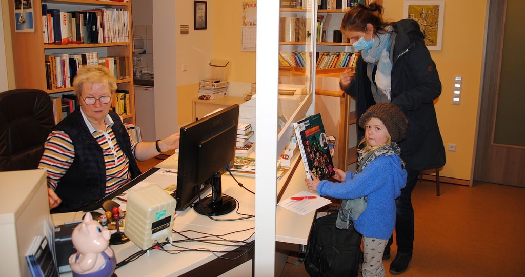 Die Siebenlindenerin Alexandra Gottwald und ihre Tochter Luna gehören zu den regelmäßigen Besuchern der Beetzendorfer Bibliothek. Bibliothekarin Brigitte Wiswede (links) scannt den Code der ausgesuchten Bücher ein.