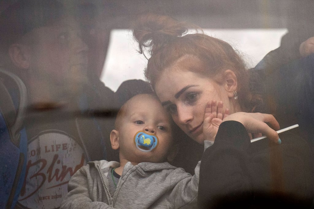 Eine Frau hält ihr Baby in einem Bus, während sie Kiew verlässt.