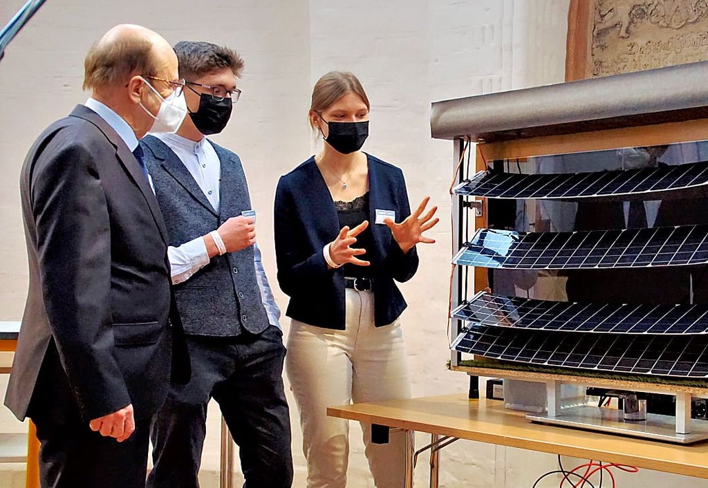 Oberbürgermeister Klaus Schmotz lässt sich die Photovoltaik-Lamellen von Chris Julian Erdmann (19) und Finja Alpert (16) erklären. Die beiden sind Schüler im Stendaler Winckelmann-Gymnasium.