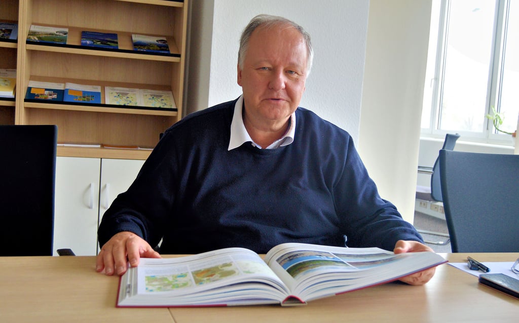 Herausgeber Andreas Berkner von der Kulturstiftung Hohenmölsen blättert in seinem neuen Buch über die bergbaubedingte Umsiedlungsgeschichte in Mitteldeutschland.