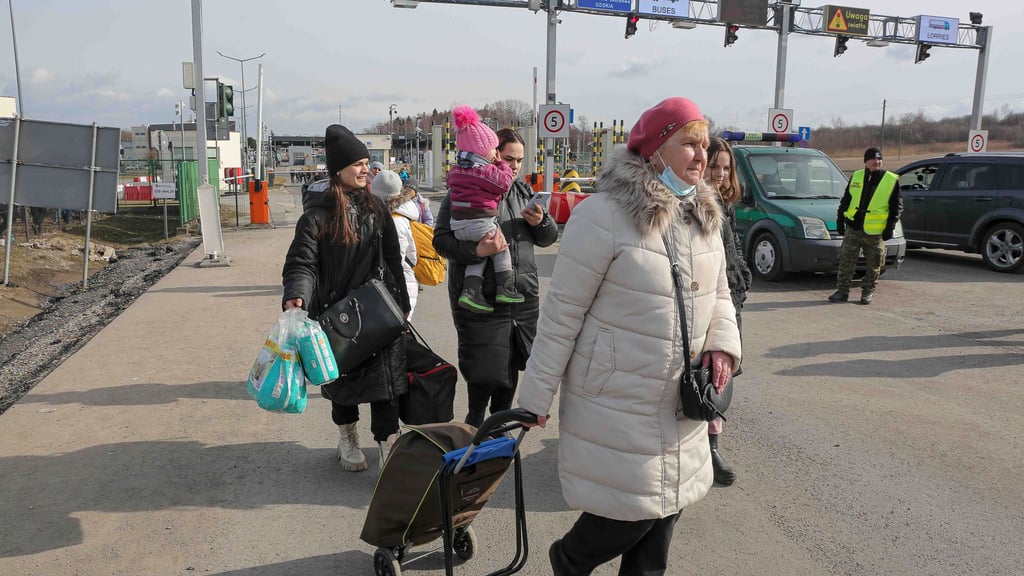 Ukrainische Geflüchtete kommen am polnischen Grenzübergang an. Wegen des russischen Angriffs auf die Ukraine sind nach Schätzungen des UN-Flüchtlingshilfswerks (UNHCR) bisher weit mehr als 100 000 Menschen in Nachbarländer geflüchtet.