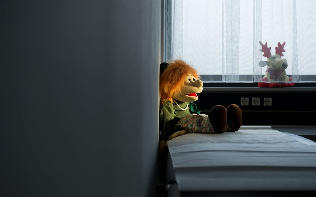 Eine Handpuppe sitzt auf einer Liege in einem Untersuchungsraum in einer Kinderschutzambulanz. Die Uni Magdeburg hat eine App entwickelt, die sich an Menschen mit pädophilen Neigungen richtet und sie zu einer Beratung animieren soll.