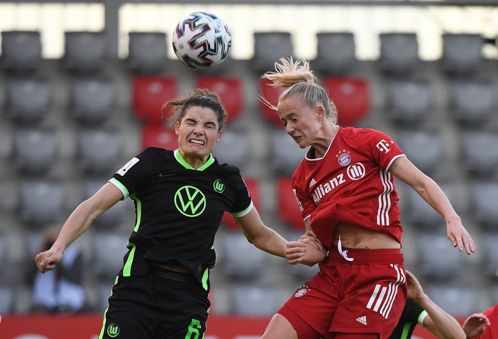 Münchens Lea Schüller (r) und Wolfsburgs Dominique Janssen kämpfen beim Kopfballduell um den Ball.