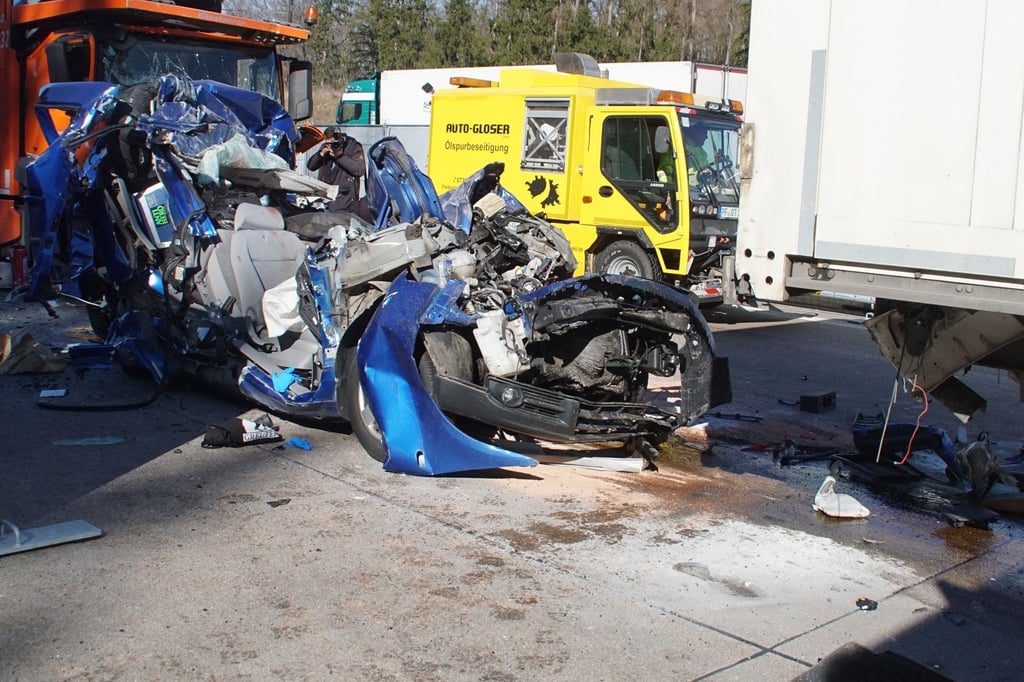 Das Auto völlig zerstörte Auto geriet zwischen zwei Lastwagen, zwei Menschen sind bei dem Unfall auf der A8 ums Leben gekommen.