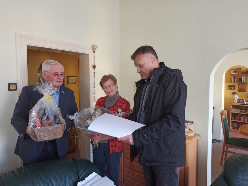 Ulrich und Helga Walstorf nehmen die Glückwünsche und Geschenke des Ortes, der Gemeinde und des Landes vom Biederitzer Ortsbürgermeister Carsten Schneider (r.) entgegen.