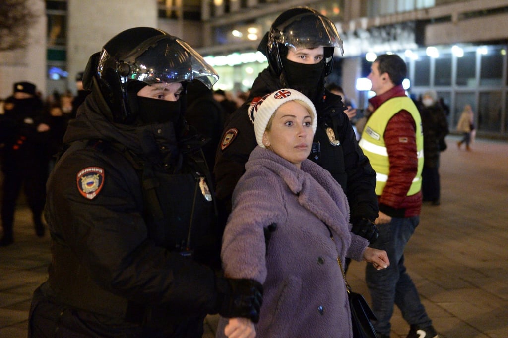 Zwei Polizisten nehmen eine Frau während einer Demonstration in Moskau gegen die russische Invasion in die Ukraine fest.