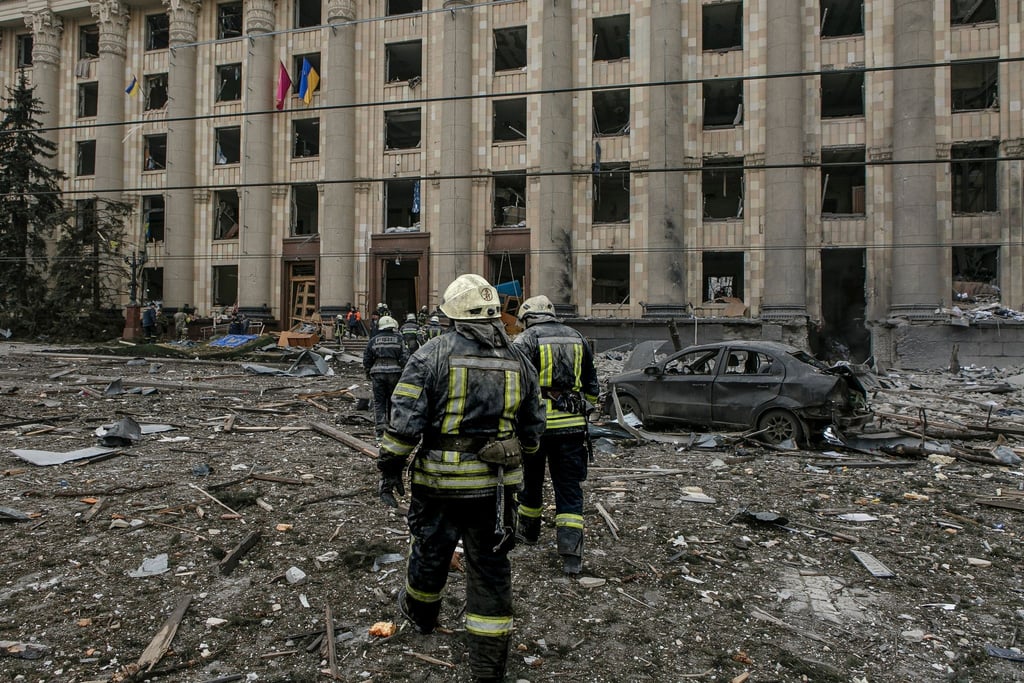 Ukrainische Rettungskräfte arbeiten vor dem beschädigten Rathausgebäude in Charkiw nach dem russischen Beschuss.