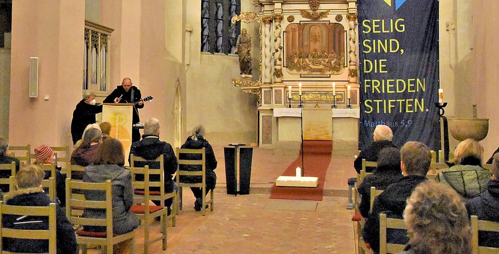 Beim ersten Friedensgebet in der Haldensleber St. Marien-Kirche wurden Kerzen in den Altarraum gestellt, die Teilnehmer sangen und beteten gemeinsam.