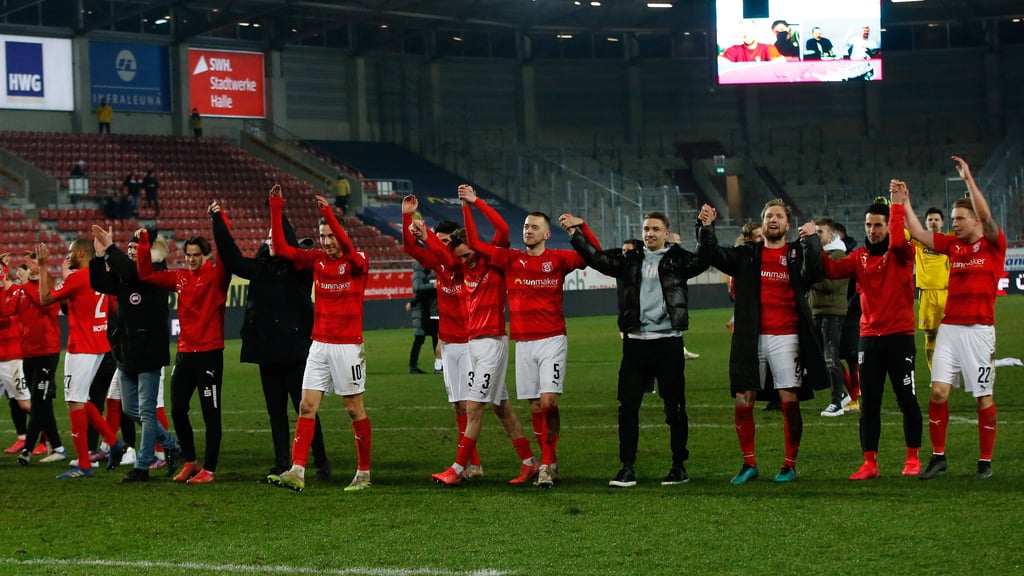Die Mannschaft des Halleschen FC feiert den Sieg gegen Viktoria Berlin mit den Fans.