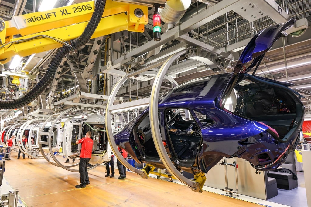 Mitarbeiter montieren Komponenten an Porsche Macan und Panamera im Leipziger Werk.