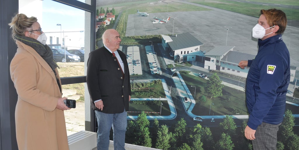 An einem Foto im Erdgeschoss des Towers stellte Daniel Sülberg (rechts) den Landtagsabgeordneten Kathrin Tarricone und Johann Hauser das Nationale Erprobungszentrum für Unbemannte Luftfahrtsysteme in Cochstedt vor.