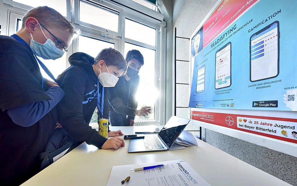 Noah König aus Dessau (r.) zeigt Schülern seine Leselern-App.