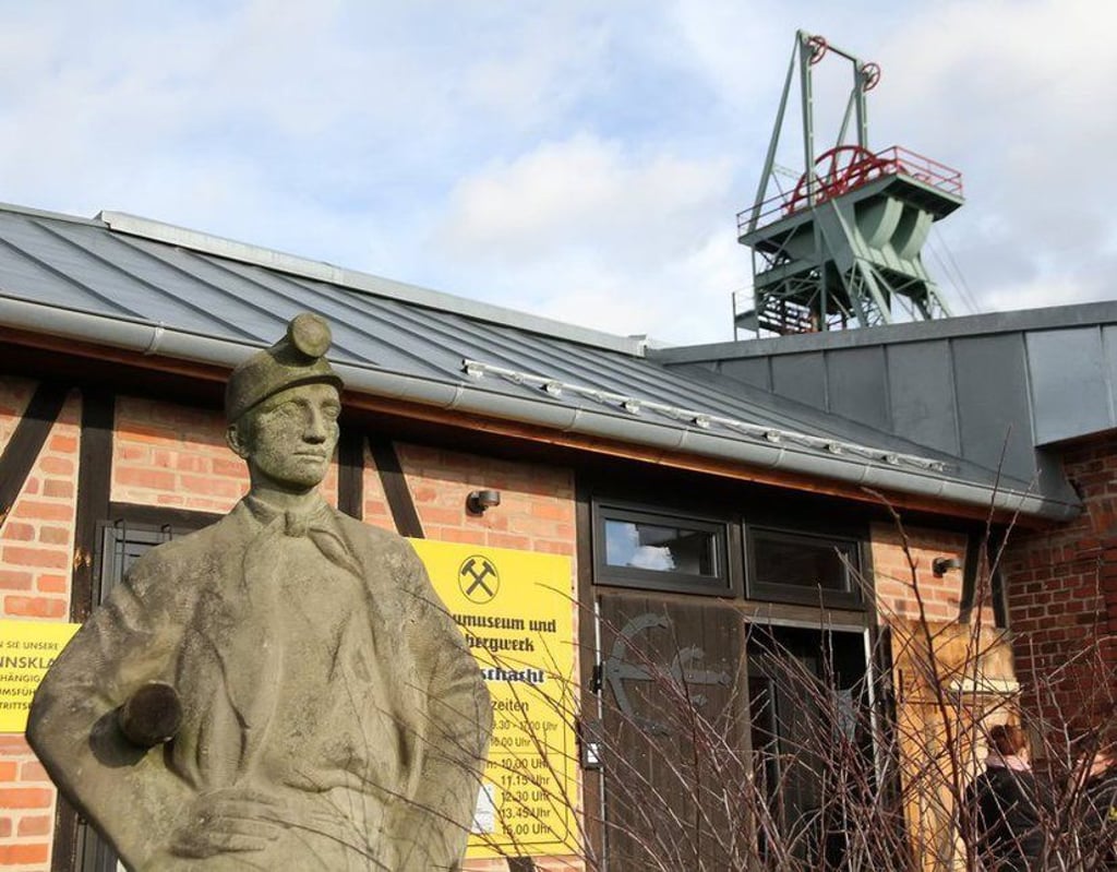 Blick auf den Eingang des Schaubergwerks, hinten ist das Fördergerüst zu sehen.