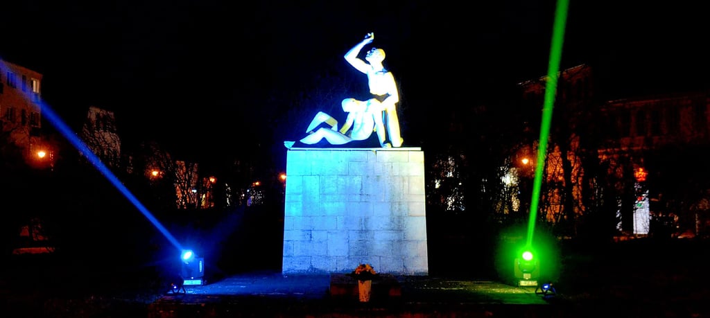 Dieses Bild bedarf keiner Worte: Das Mahnmal hell erleuchtet, und die Farben der Ukraine strahlen in den Himmel.