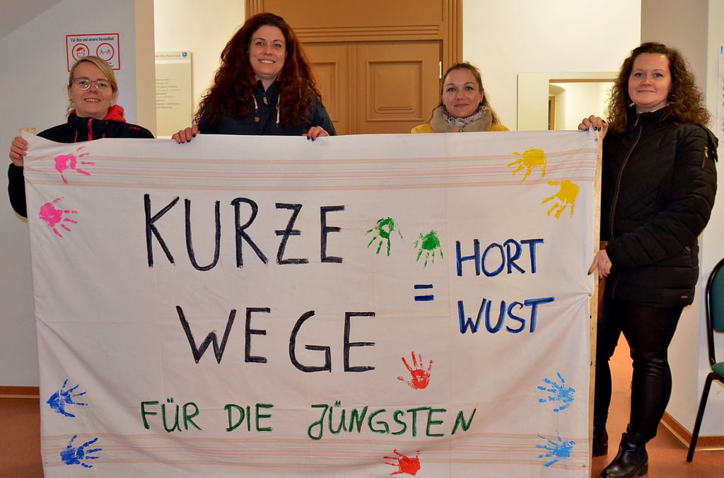 Vier empörte Mütter von Wuster Kindern hatten sich mit diesem Transparent zur Hauptausschusssitzung nach Schönhausen begeben. Nicole Kieschke (2. von links) trug viele Argumente für einen Erhalt des Wuster Hortes vor.