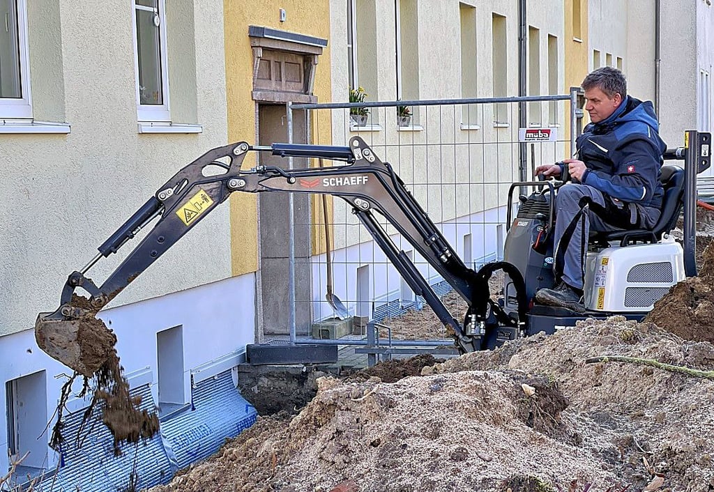 Gunnar Steuer baggert am im Erdreich an Wohnblöcken in der Havelberger Karl-Liebknechtsraße.