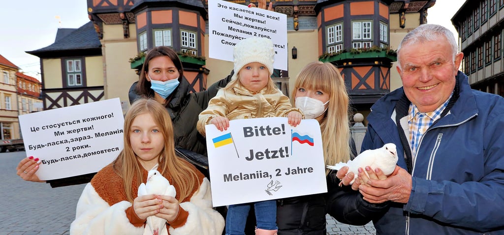 Friedensaktion auf dem Wernigeröder Markt: Die geflüchteten Ukrainerinnen Anna Efimenko (hinten links) und Olga Sydorenko (2. v. rechts) – mit ihren Kindern Melaniia und Arina (links) – bitten mit Taubenzüchter Bernd Rettmer aus Reddeber mit weißen Friedenstauben um ein Ende des Krieges in ihrer Heimat.