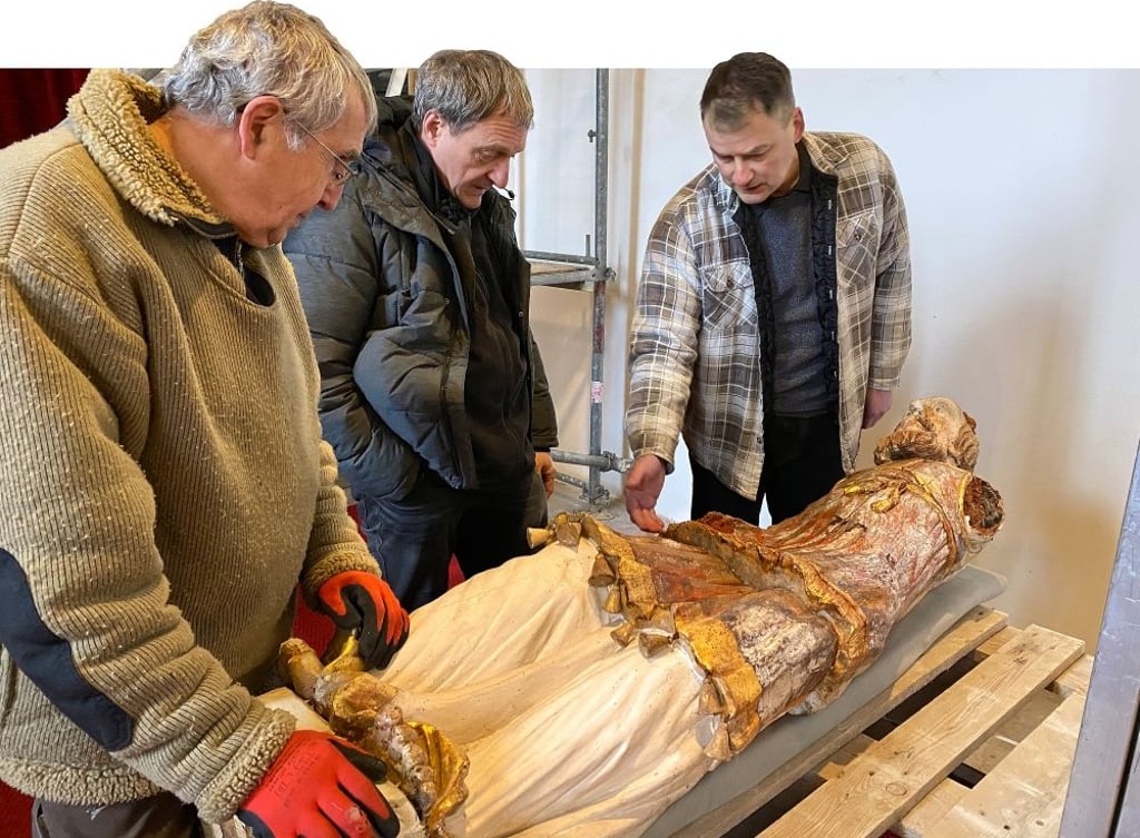 Klaus Wende vom Gemeindekirchenrat, Restaurator Dirk Jacobs aus Berlin und Holzbildhauer Uwe Bormann aus Rieder (von links) begutachten die Aaron-Figur noch einmal ganz genau, bevor sie sicher verpackt auf den Weg in die Hauptstadt geschickt wird.
